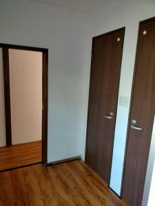 two doors in an empty room with wood floors at Neko Neko La Campagne in Tamba