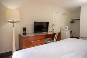 a bedroom with a bed and a tv on a dresser at Riverfront Inn Roseburg in Roseburg