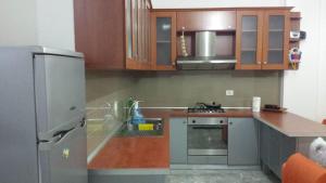 a kitchen with wooden cabinets and a stainless steel refrigerator at Holidays Home Priam in Golem