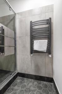 ein Bad mit einer Dusche und einem weißen Handtuch in der Unterkunft Chopin Park Apartments in Posen