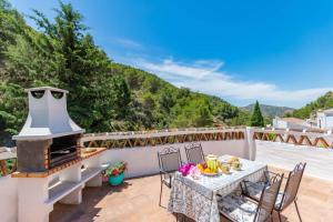 patio z kominkiem, stołem i krzesłami w obiekcie Casa Rosa, con encanto y piscina climatizada w mieście Frigiliana