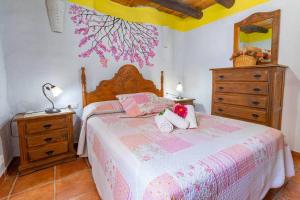 sypialnia z łóżkiem z 2 ręcznikami i komodą w obiekcie Casa Rosa, con encanto y piscina climatizada w mieście Frigiliana