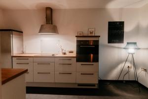 eine Küche mit weißen Schränken, einer Spüle und einer Lampe in der Unterkunft Monteurzimmer Pavan Luxemburg, Saarbrücken, Überherrn Pavan T2-KEINE Ferienwohnung in Saarlouis
