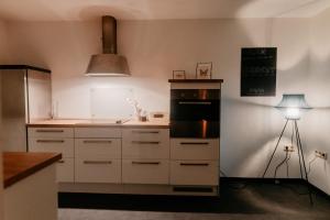 a kitchen with white cabinets and a sink and a lamp at Monteurzimmer Pavan, T2, Luxemburg, Saarbrücken, Überherrn-KEINE Ferienwohnung in Saarlouis