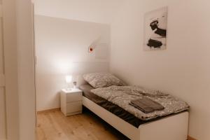 ein kleines Schlafzimmer mit einem Bett und einem Nachttisch in der Unterkunft Monteurzimmer Pavan Luxemburg, Saarbrücken, Überherrn Pavan T2-KEINE Ferienwohnung in Saarlouis