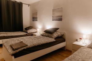 two beds in a room with two lamps and two beds at Monteurzimmer Pavan, T2, Luxemburg, Saarbrücken, Überherrn-KEINE Ferienwohnung in Saarlouis +25 photos