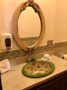a bathroom with a green sink and a mirror at Hotel T KON T in Antigua Guatemala