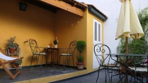 un patio con sillas, una mesa y una sombrilla en Domus Duorum, en Oporto