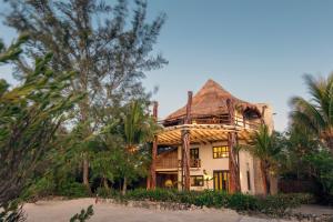 a large building with a tree in front of it at Hotel Villas Flamingos in Holbox Island