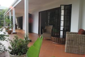 un patio con sillas, una mesa y algunas plantas en Lucky Bean Guesthouse, en Johannesburgo