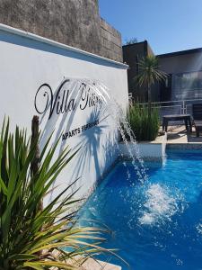 un panneau sur le côté d'un bâtiment avec une piscine dans l'établissement Aparts serranos, à San Antonio de Arredondo