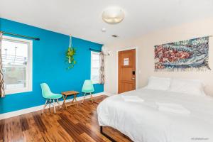 1 dormitorio con paredes azules, 1 cama y 2 sillas en Samesun Ocean Beach Hotel & Hostel, en San Diego
