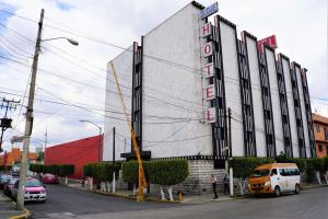 a building on a street with cars parked in front of it at Hotel Duque in Mexico City