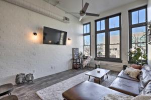 a living room with a couch and a tv on a wall at Chic SLC Downtown Studio Loft Walk to Shops in Salt Lake City