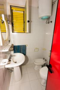 een witte badkamer met een wastafel en een toilet bij Baia Verde 10 in Baia Verde +5 foto's