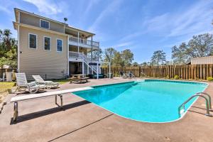 a swimming pool in front of a house at Spacious Gulf Shores Hideaway with Pool and Deck! in Gulf Shores
