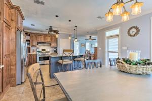 a kitchen and dining room with a table and chairs at Spacious Gulf Shores Hideaway with Pool and Deck! in Gulf Shores