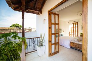 a bedroom with a bed and a balcony at Bioma Boutique Hotel in Mompos