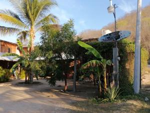 a surfboard on a pole next to a street at Cabañas jaysur in Barra de la Cruz