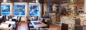restauracja ze stołami i krzesłami oraz choinką świąteczną w obiekcie Ristorante Con alloggio Val Sole w mieście Acquarossa