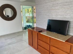 a flat screen tv sitting on top of a wooden dresser at Casa de las Palmeras Lomas de Cocoyoc in Atlatlahucan