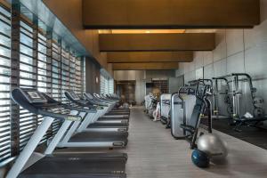 a gym with a row of treadms and machines at Regent Shanghai Pudong - Complimentary first round minibar per stay - including a bottle of wine in Shanghai