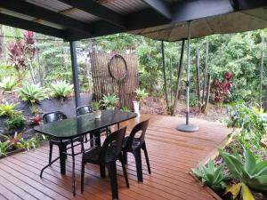 a table and chairs on a wooden deck with an umbrella at Stay @ The Cube in Montville