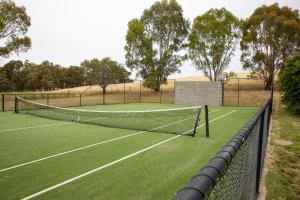 una pista de tenis con una red en un campo en CHARTER FARM - FIND YOUR HAPPY HAMLET, 
