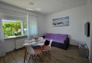 ein Wohnzimmer mit einem Tisch und einem Bett in der Unterkunft Apartment Happy sound in Rijeka
