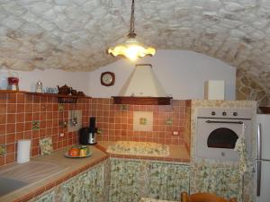 a kitchen with a stove top oven next to a counter at La Casa di Petra in Modica