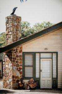 una casa con un garaje con una pared de piedra en Olinda Yarra Cottage, en Yering