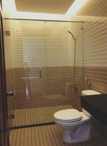a bathroom with a toilet and a glass shower at Vân Trang Hotel in Vĩnh Long