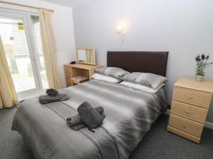 a bedroom with a large bed with towels on it at Running Waters in Callington