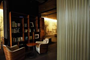 um quarto com duas cadeiras e uma estante de livros com livros em The Nook Hotel Hangzhou - A design hotel, Near subway em Hangzhou