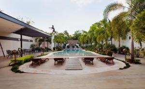 a pool in a courtyard with chairs and a fountain at Hotel & Suites Country Valladolid in Valladolid