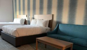 pokój hotelowy z łóżkiem i kanapą w obiekcie Meridian Inn & Suites Regina Airport w mieście Regina