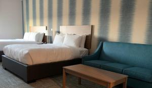 a hotel room with a bed and a couch at Meridian Inn & Suites Regina Airport in Regina