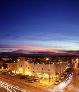 a city at night with cars parked in a parking lot at BEHRAMPAŞA OTEL &CAFE &RESTAURANT in Sivas