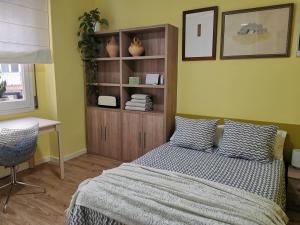 1 dormitorio con cama, escritorio y estante en Dos habitaciones dobles en apartamento confortable en Hospitalet de Llobregat