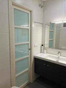 y baño con lavabo y espejo. en Dos habitaciones dobles en apartamento confortable en Hospitalet de Llobregat