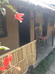 una casa con una recinzione e una sedia su un portico di My beautiful cottage in pokhara a Pokhara