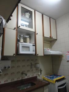 a kitchen with a sink and a microwave at Apartamento Copacabana 243 in Rio de Janeiro