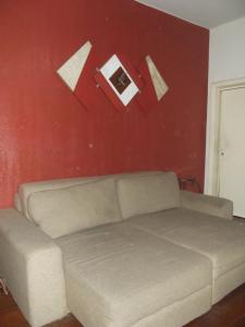 a living room with a couch and a red wall at Apartamento Copacabana 243 in Rio de Janeiro