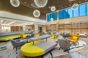 a lobby of a store with yellow chairs and tables at Holiday Inn Shanghai Dishui Lake, an IHG Hotel in Nanhui