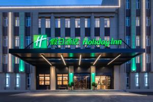 a hotel with a sign on the front of a building at Holiday Inn Shanghai Dishui Lake, an IHG Hotel in Nanhui