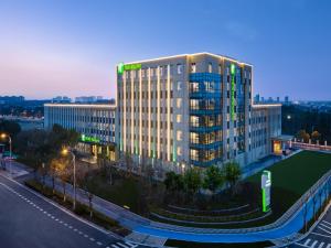 a tall building with a lit up sign on it at Holiday Inn Shanghai Dishui Lake, an IHG Hotel in Nanhui