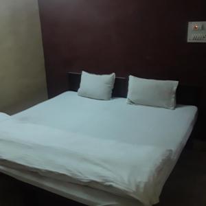a large white bed with two pillows on it at shri bake bihari guest house in Gwalior