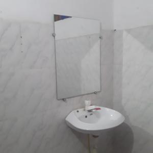 Baño blanco con lavabo y espejo en shri bake bihari guest house en Gwalior