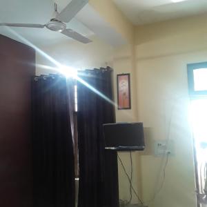 a room with a ceiling fan and a black curtain at shri bake bihari guest house in Gwalior