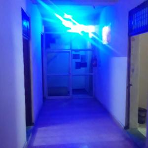 un pasillo oscuro con luces azules y verdes en shri bake bihari guest house, en Gwalior